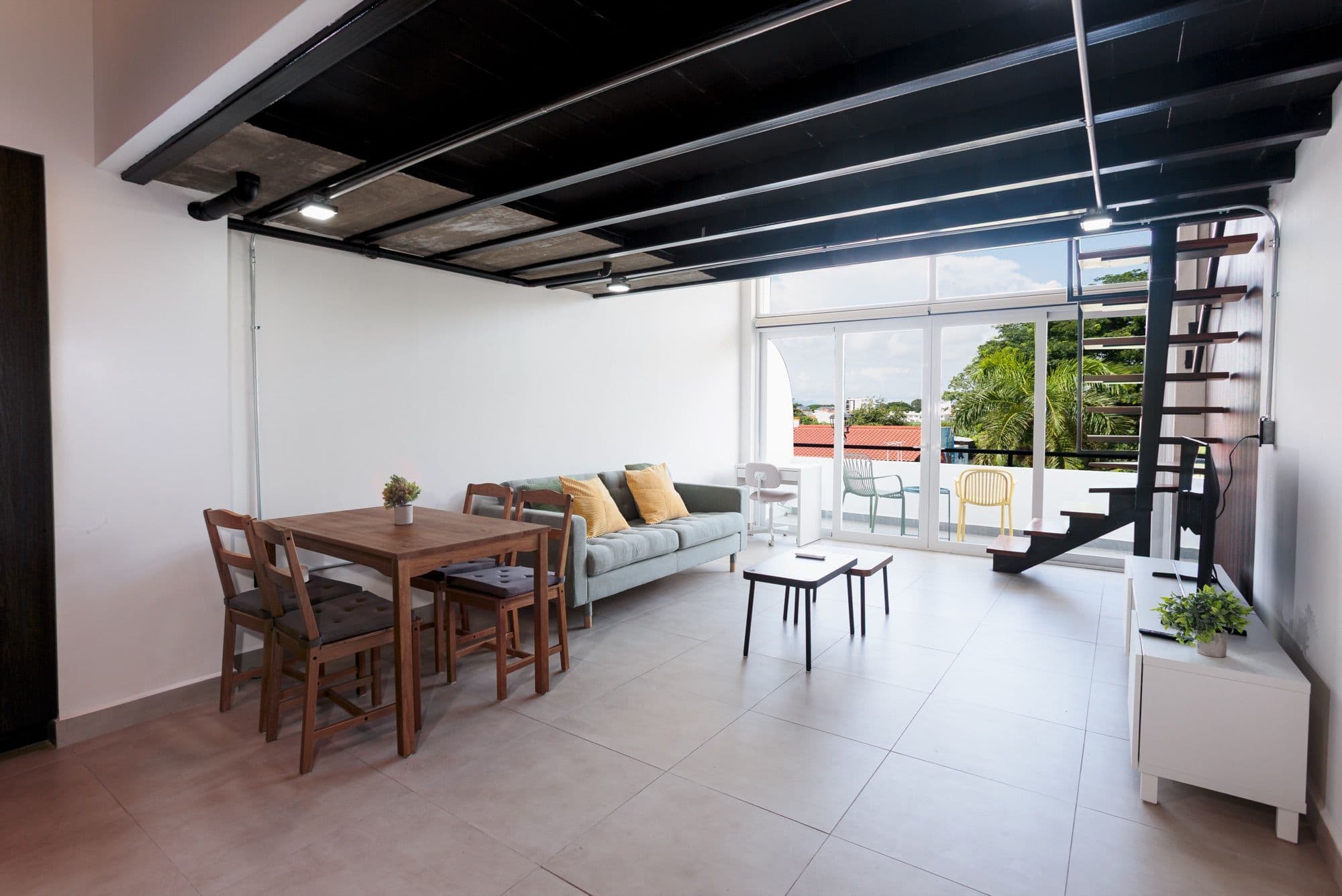 Sala de Luna que se abre a un balcón privado, con escalera de caracol hacia el mezzanine.